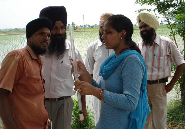 A researcher explaining tensiometer technology to farmers.